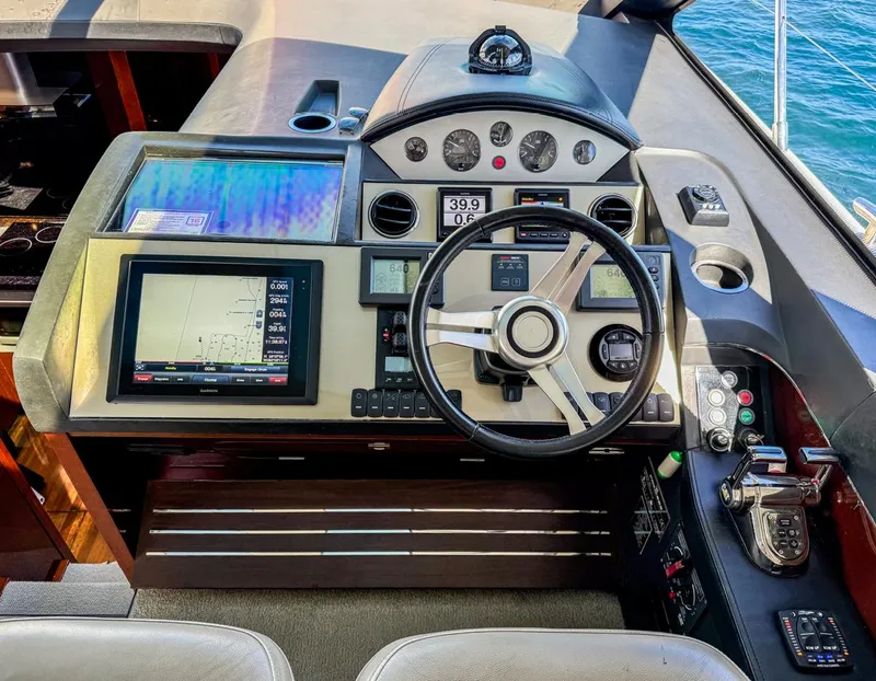 Slide: The Image of 2015 Princess V52 yacht helm with navigation screens and steering wheel. - 8