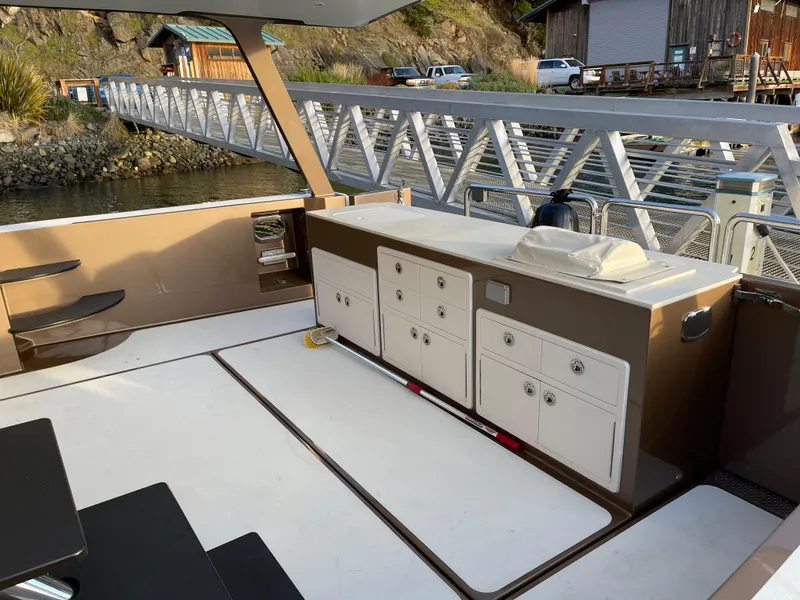 Slide: The Image of Outdoor kitchen on a 2012 Coastal Craft 56 yacht, docked at a marina. - 15