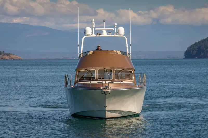 Slide: The Image of 2012 Coastal Craft 56 yacht cruising on serene waters with scenic island backdrop. - 4