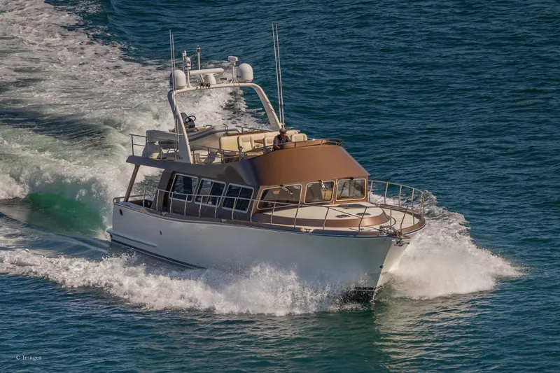Slide: The Image of 2012 Coastal Craft 56 yacht cruising on open water, leaving a foamy wake. - 5