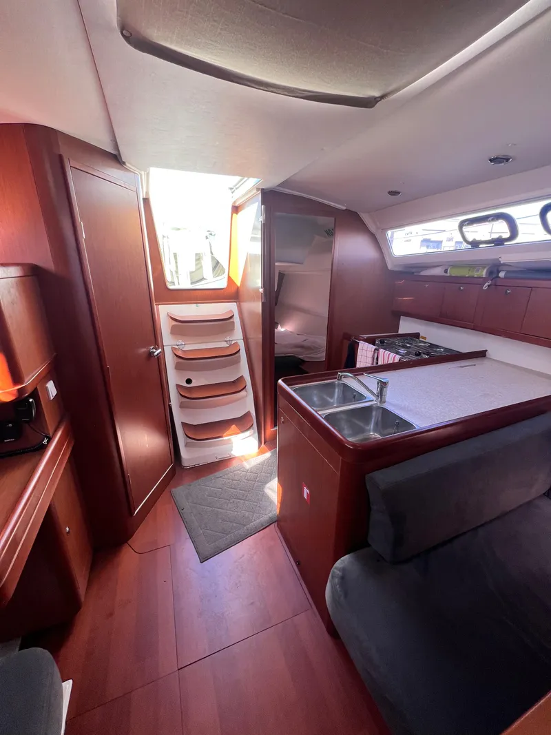 Slide: The Image of Interior of 2013 Beneteau 37 sailboat, featuring kitchen and seating area. - 15