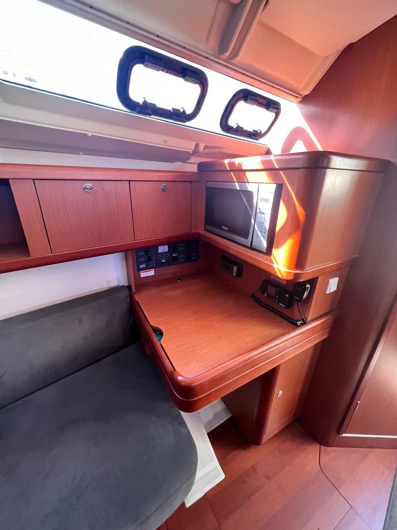 Slide: The Image of 2013 Beneteau 37 yacht interior with wooden desk, storage, and seating. - 16