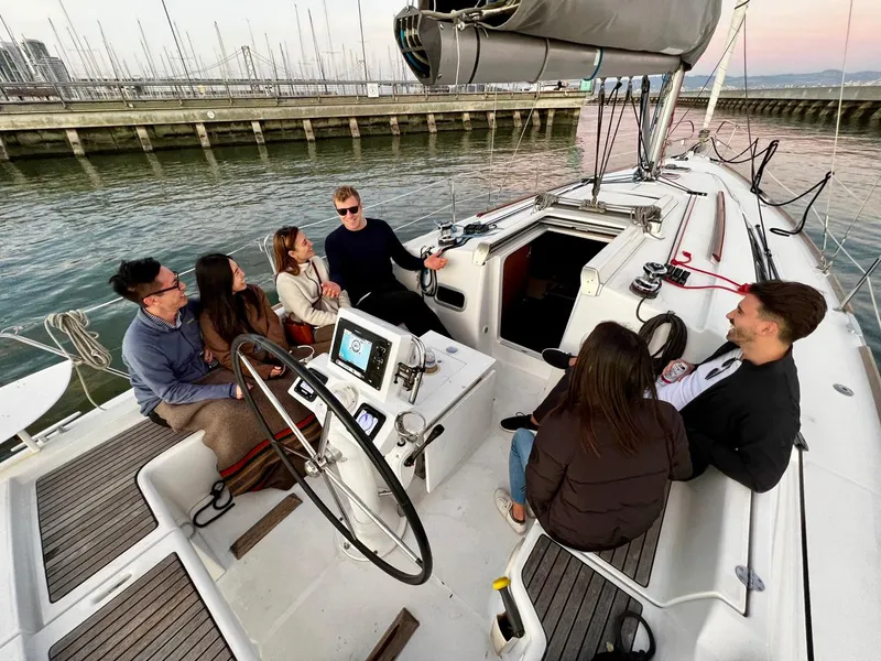 Slide: The Image of Group enjoying a conversation on a 2013 Beneteau 37 sailboat docked at a marina. - 17