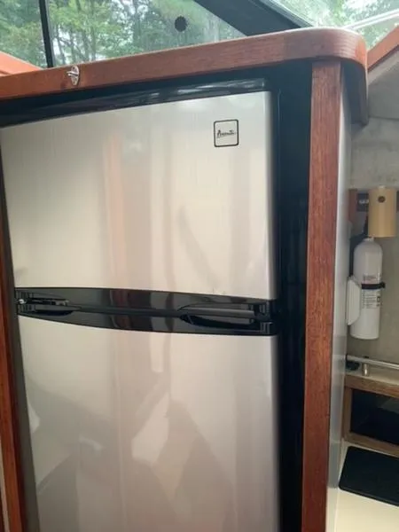 Slide: The Image of Stainless steel refrigerator inside 1985 Carver 3227 Convertible boat kitchen. - 11