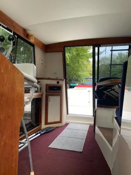 Slide: The Image of Interior of 1985 Carver 3227 Convertible boat with open sliding door and seating area. - 14