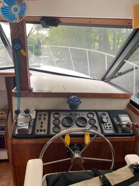 Slide: The Image of 1985 Carver 3227 Convertible boat helm with vintage controls and steering wheel. - 5