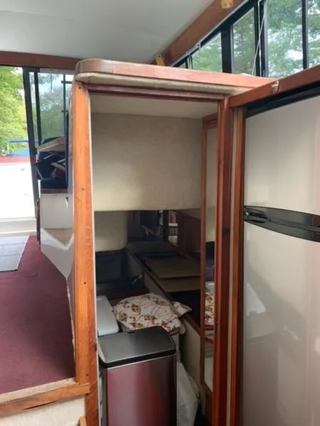 Slide: The Image of Interior of 1985 Carver 3227 Convertible boat with wood accents and compact living space. - 6