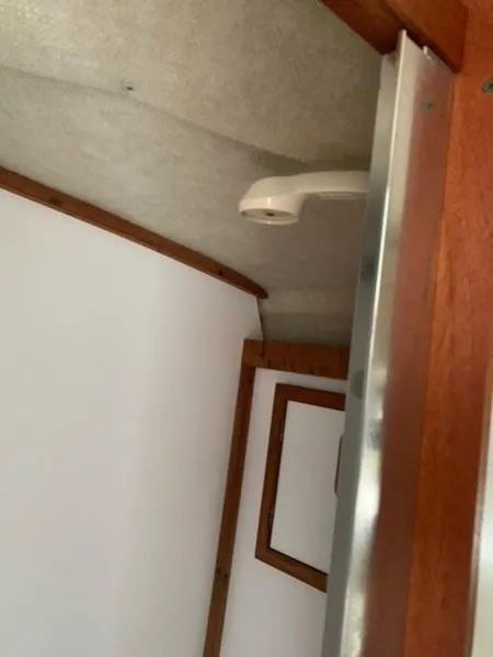 Slide: The Image of Interior of 1985 Carver 3227 Convertible boat with wood trim and ceiling detail. - 9