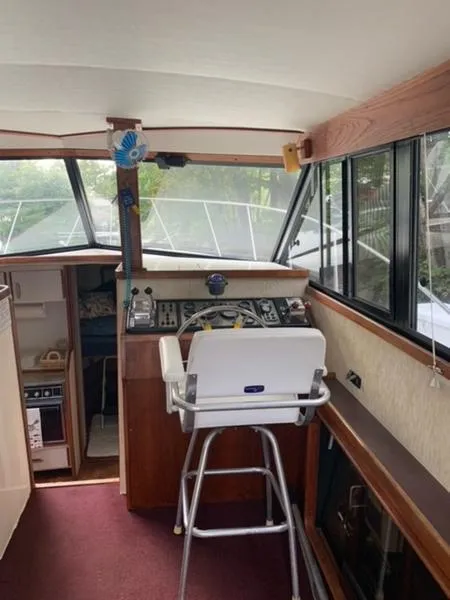 Slide: The Image of Interior of 1985 Carver 3227 Convertible boat with helm and seating. - 12