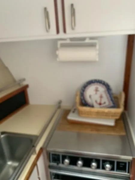 Slide: The Image of Compact kitchen in 1985 Carver 3227 Convertible boat with stove and nautical decor. - 13