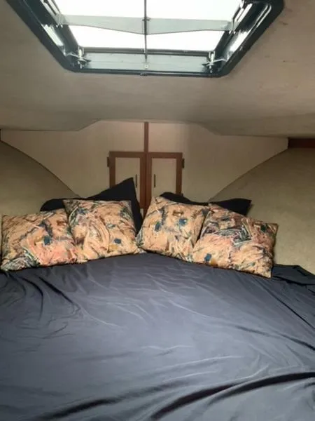 Slide: The Image of Cozy cabin interior of 1985 Carver 3227 Convertible with skylight and floral pillows. - 15