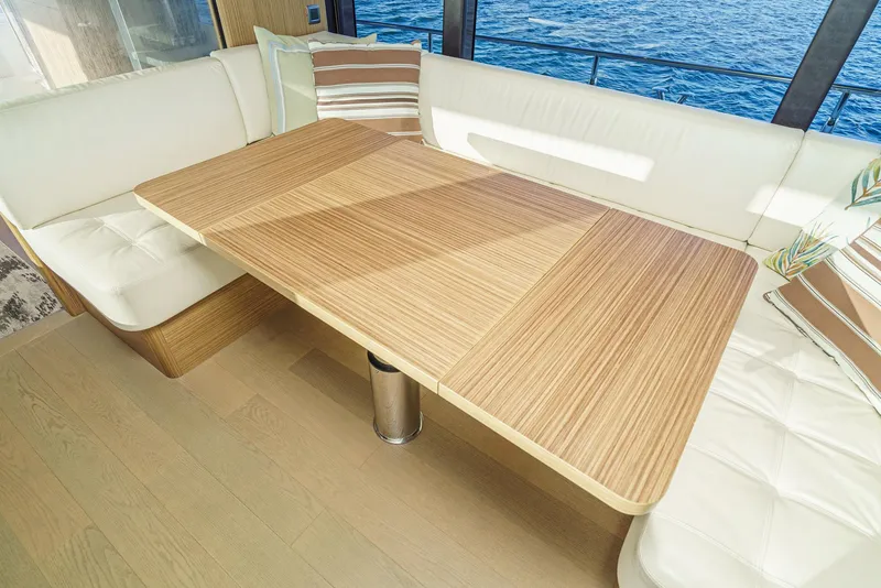 Slide: The Image of Luxurious 2017 Absolute NAVETTA yacht interior with elegant wooden table and plush seating. - 18