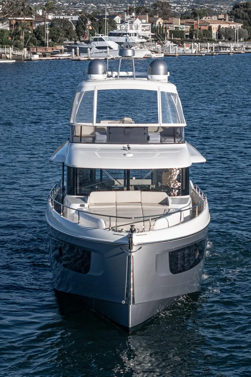 Slide: The Image of Luxury 2017 Absolute NAVETTA yacht on serene water near a coastal town. - 2