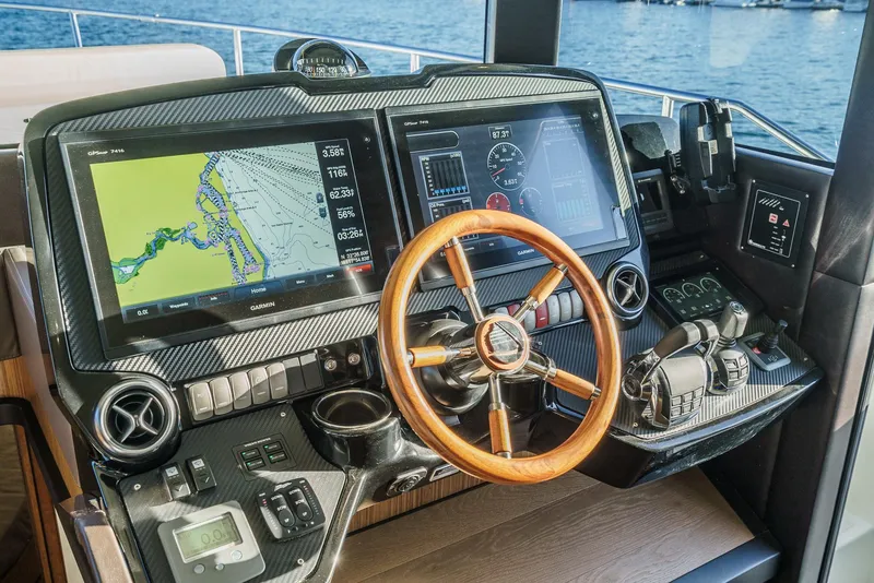 Slide: The Image of Cockpit of 2017 Absolute NAVETTA yacht with navigation screens and wooden steering wheel. - 21