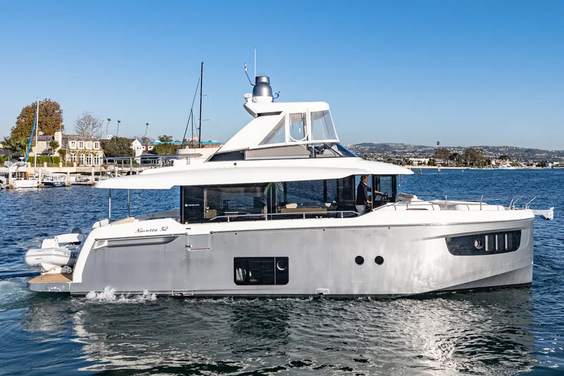 Slide: The Image of 2017 Absolute NAVETTA yacht cruising on a sunny day near a coastal town. - 70