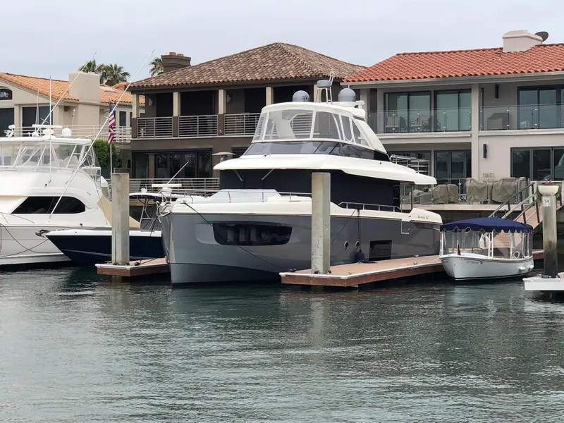 Slide: The Image of 2017 Absolute NAVETTA yacht docked at marina, surrounded by other boats and waterfront homes. - 76