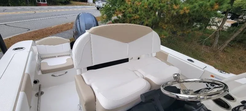 Slide: The Image of 2021 Robalo R200 boat interior with beige and white seating, steering wheel, and outboard motor. - 13
