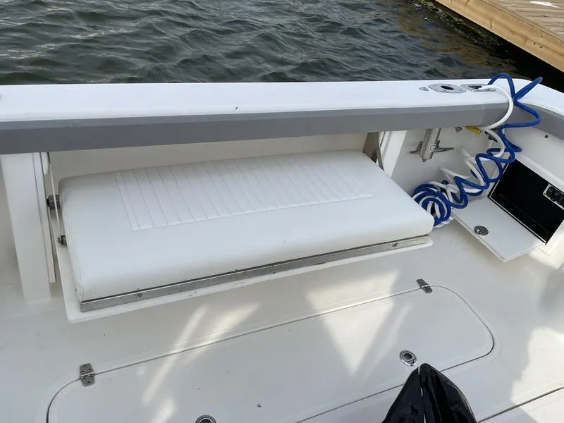Slide: The Image of 2016 Jarrett Bay 32 Walk Around boat interior with white seating and blue hose. - 25