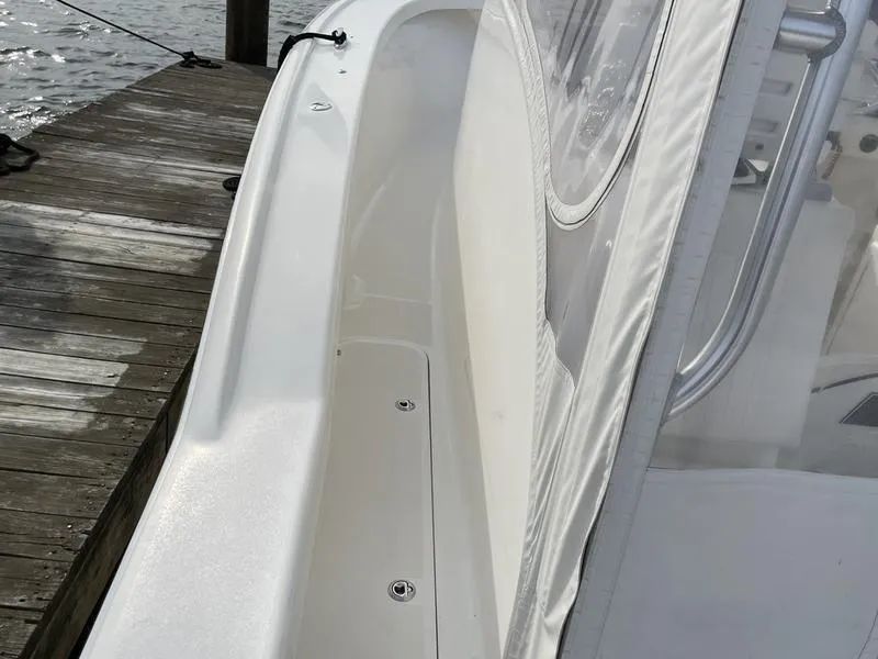 Slide: The Image of 2016 Jarrett Bay 32 Walk Around boat docked, showcasing sleek white deck design. - 34