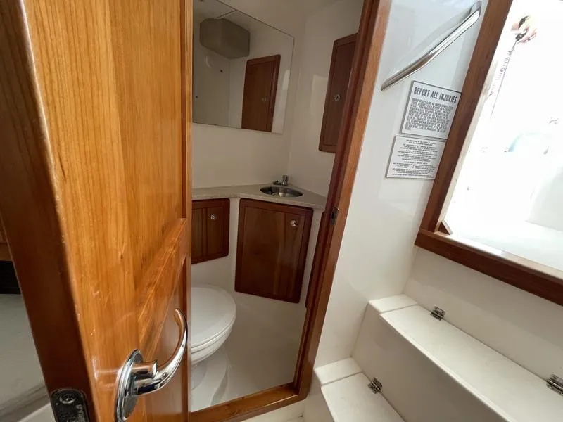 Slide: The Image of Interior of 2016 Jarrett Bay 32 Walk Around boat bathroom with wooden door and cabinets. - 42
