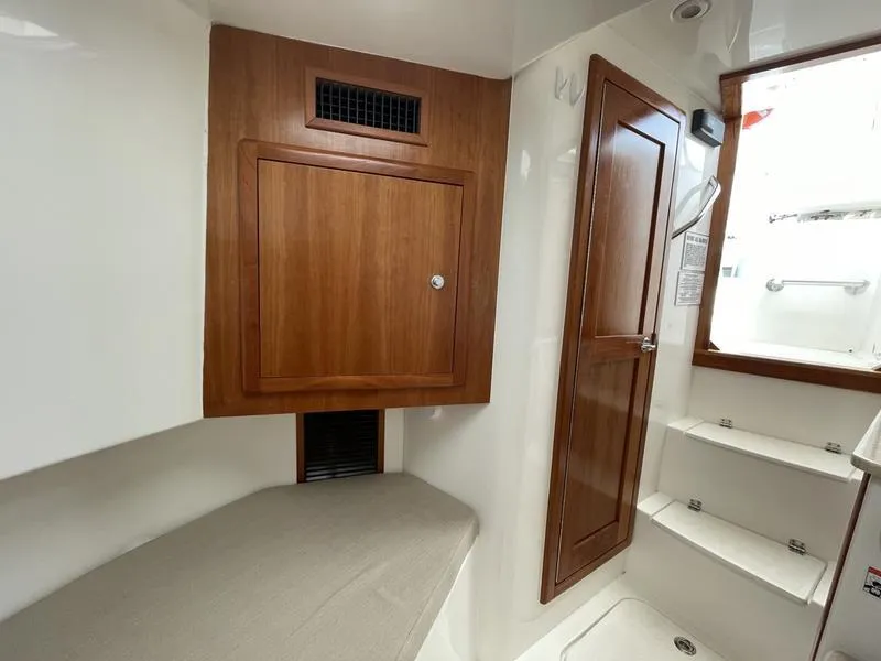 Slide: The Image of 2016 Jarrett Bay 32 Walk Around cabin interior with wood accents and seating area. - 44
