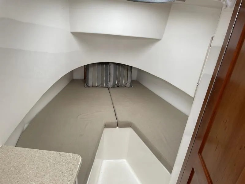 Slide: The Image of 2016 Jarrett Bay 32 Walk Around cabin interior with bed and striped pillows. - 49