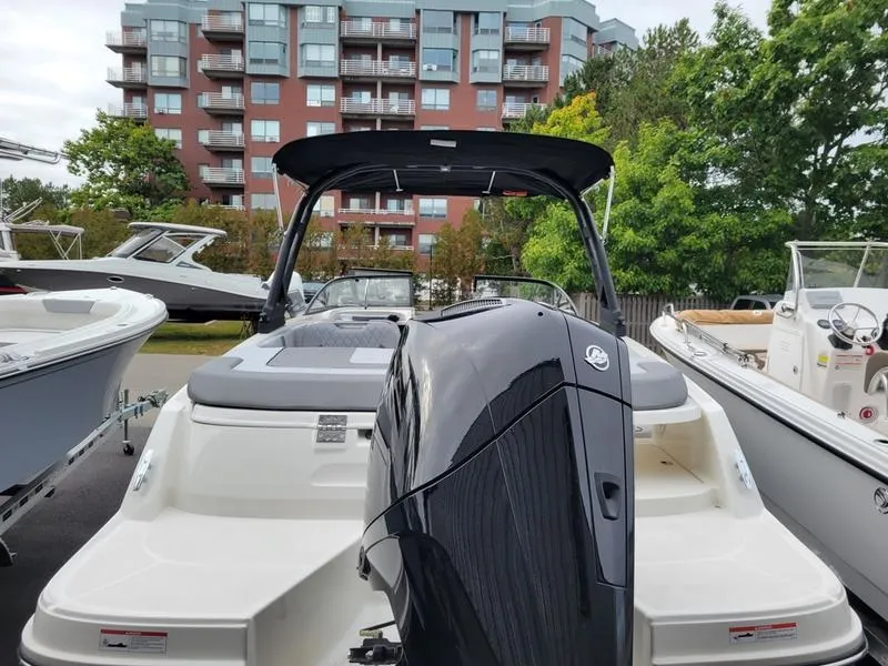 Slide: The Image of 2025 Bayliner VR6 OB boat with outboard motor, docked near modern buildings. - 3