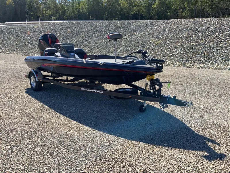 Slide: The Image of 2025 Ranger Z185 boat on trailer, parked on gravel, surrounded by trees. - 4
