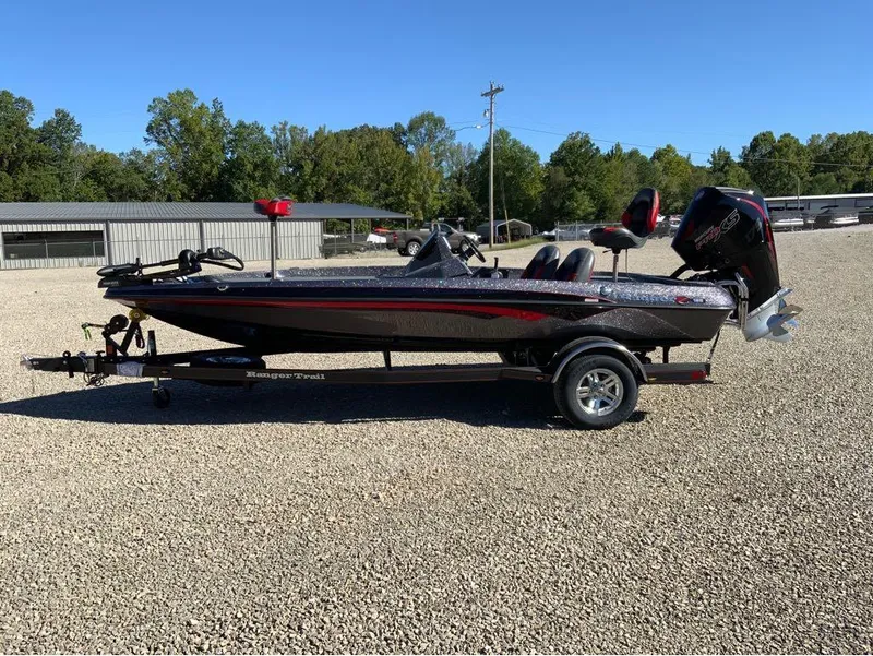 Slide: The Image of 2025 Ranger Z185 boat on trailer in gravel lot, sunny day. - 6