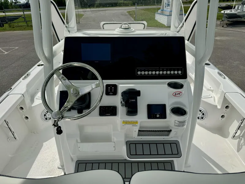 Slide: The Image of 2025 Tidewater 2210 Carolina Bay boat console with steering wheel and controls. - 9