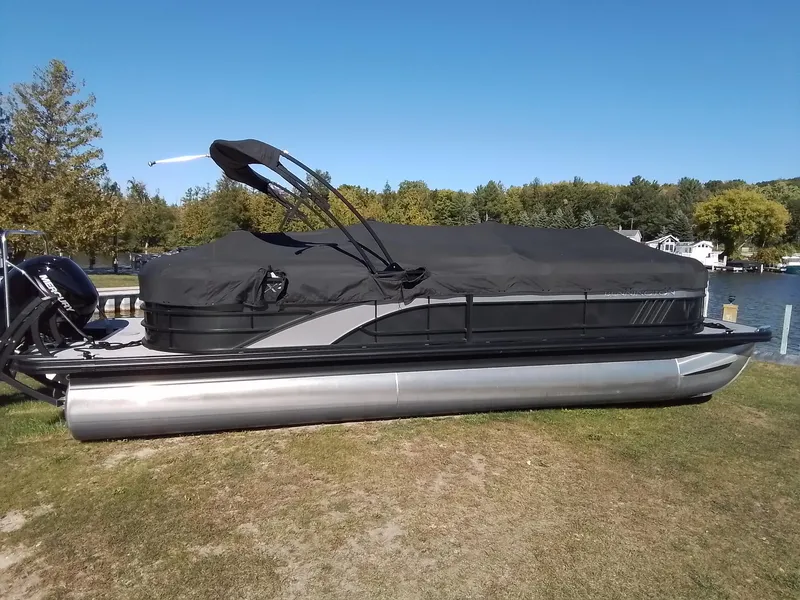Slide: The Image of 2021 Bennington Marine 24 LXSR pontoon boat with cover, parked by a scenic lake. - 12