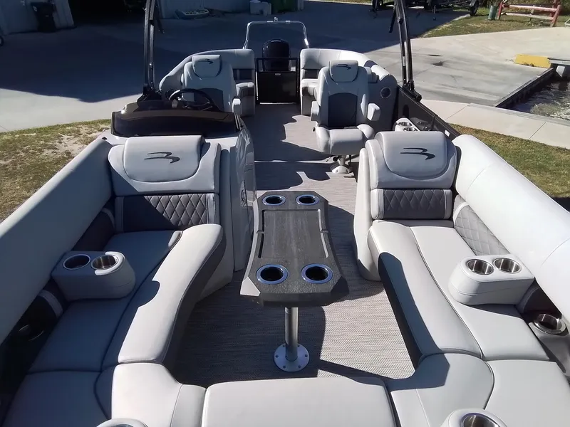 Slide: The Image of 2021 Bennington Marine 24 LXSR pontoon boat interior with luxurious seating and cup holders. - 20