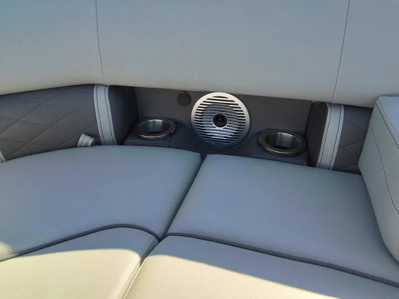 Slide: The Image of 2021 Bennington Marine 24 LXSR boat interior with cup holders and speaker. - 24