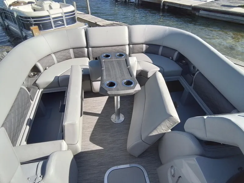 Slide: The Image of 2021 Bennington Marine 24 LXSR pontoon boat interior with gray seating and table. - 25