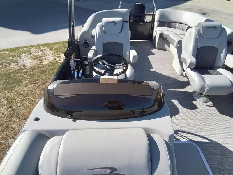 Slide: The Image of 2021 Bennington Marine 24 LXSR pontoon boat interior with plush seating and steering console. - 27