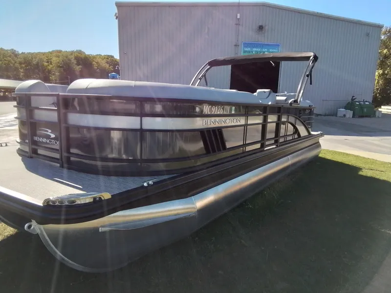 Slide: The Image of 2021 Bennington Marine 24 LXSR pontoon boat parked on grass near a building. - 4