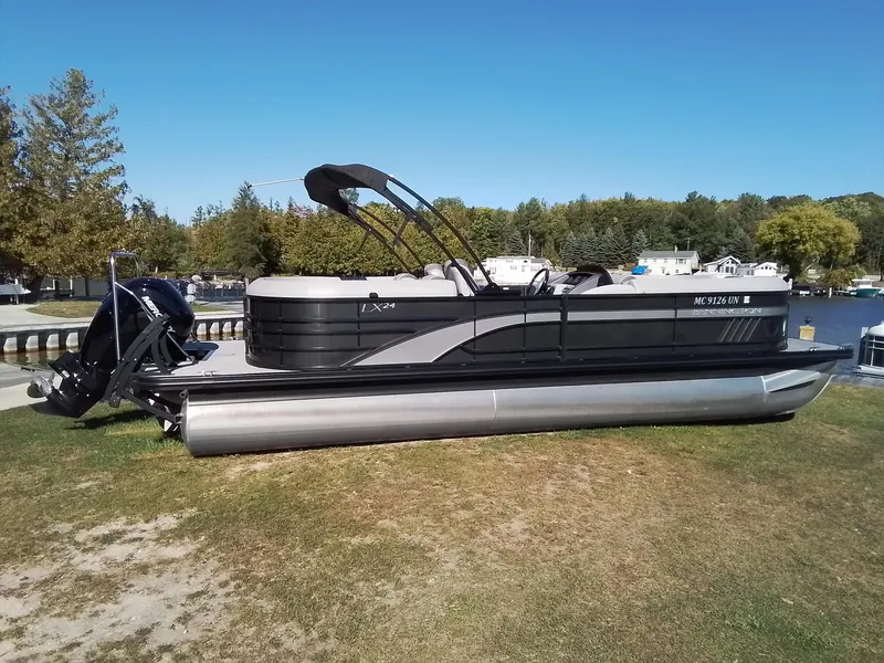 Slide: The Image of 2021 Bennington Marine 24 LXSR pontoon boat on grassy shore by a lake. - 42