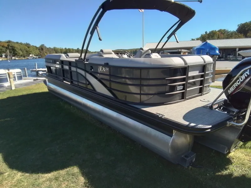 Slide: The Image of 2021 Bennington Marine 24 LXSR pontoon boat docked by a scenic lake. - 6