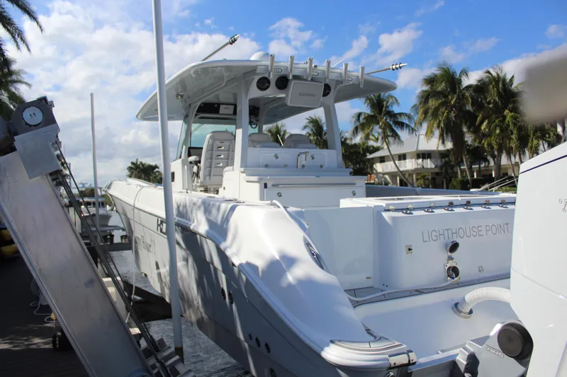 Slide: The Image of HCB 42 Lujo 2023 boat docked with palm trees in background. - 34