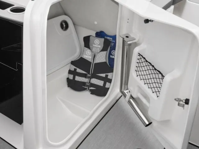 Slide: The Image of 2025 Yamaha AR250 boat storage compartment with life jackets and netted pocket. - 5