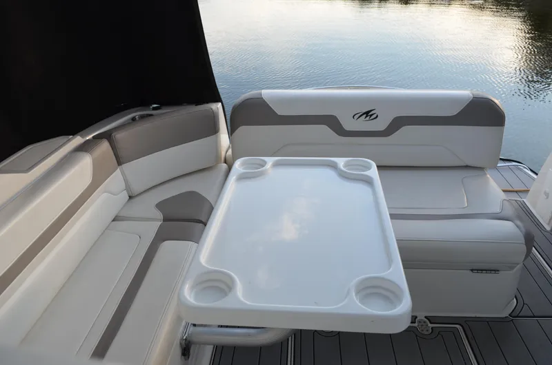 Slide: The Image of 2009 Monterey 320 Sport Yacht interior with cushioned seating and table by the water. - 10