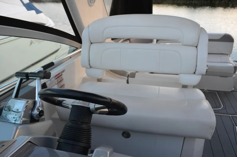 Slide: The Image of 2009 Monterey 320 Sport Yacht helm with white seating and steering wheel. - 17