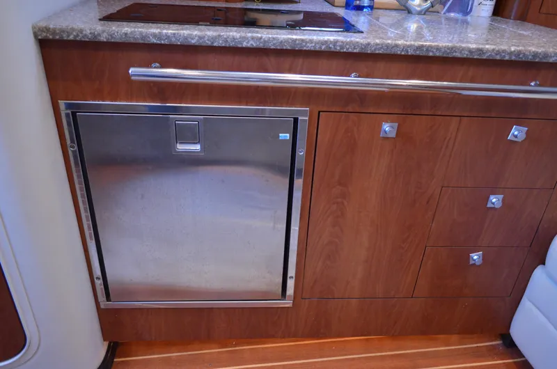 Slide: The Image of 2009 Monterey 320 Sport Yacht interior with wood cabinetry and stainless steel appliance. - 25