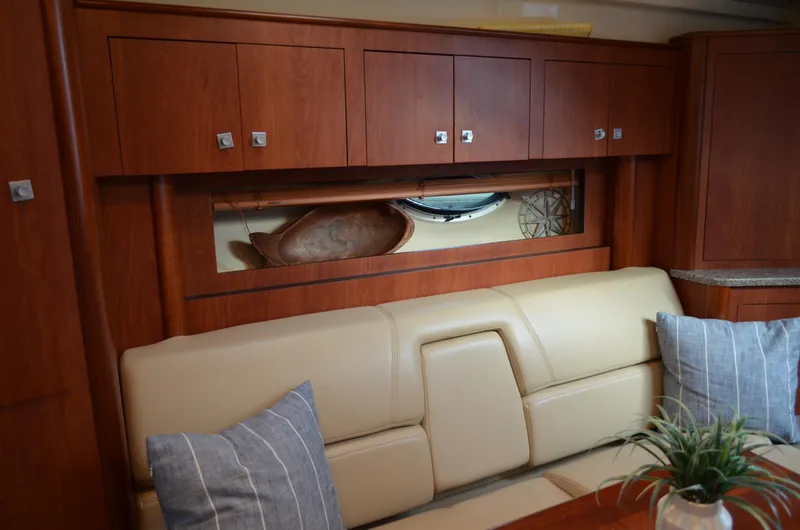 Slide: The Image of Interior of 2009 Monterey 320 Sport Yacht with wooden cabinets and beige seating. - 32