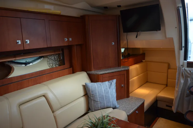 Slide: The Image of 2009 Monterey 320 Sport Yacht interior with beige seating, wooden cabinets, and mounted TV. - 33