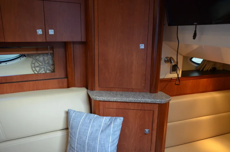 Slide: The Image of Interior of 2009 Monterey 320 Sport Yacht with wood cabinetry and beige seating. - 35