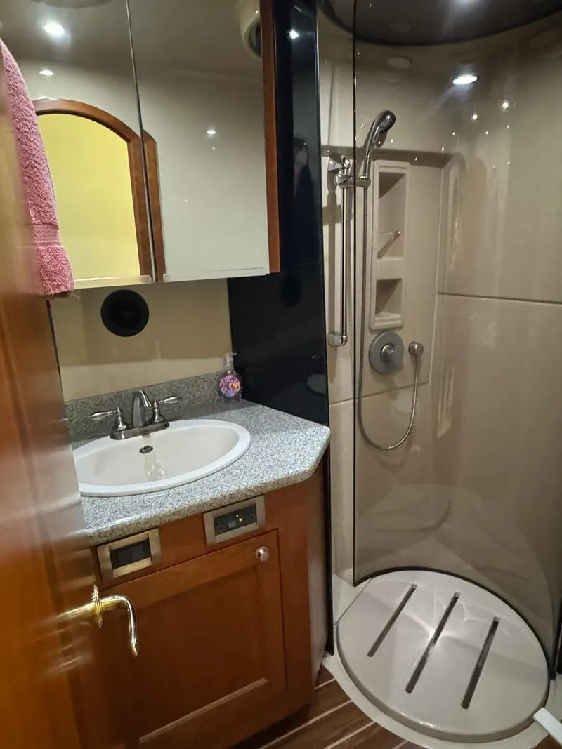 Slide: The Image of 2003 Rampage 45 Convertible yacht bathroom with shower, sink, and wooden cabinetry. - 17