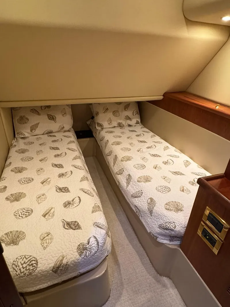 Slide: The Image of 2003 Rampage 45 Convertible cabin with twin beds and seashell-patterned bedding. - 19