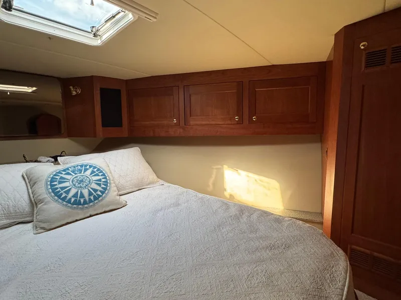 Slide: The Image of Cozy bedroom in 2003 Rampage 45 Convertible yacht with wooden cabinets and skylight. - 24