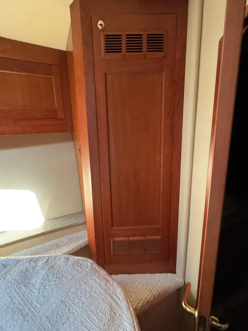 Slide: The Image of 2003 Rampage 45 Convertible interior with wooden cabinetry and cozy bedding. - 25